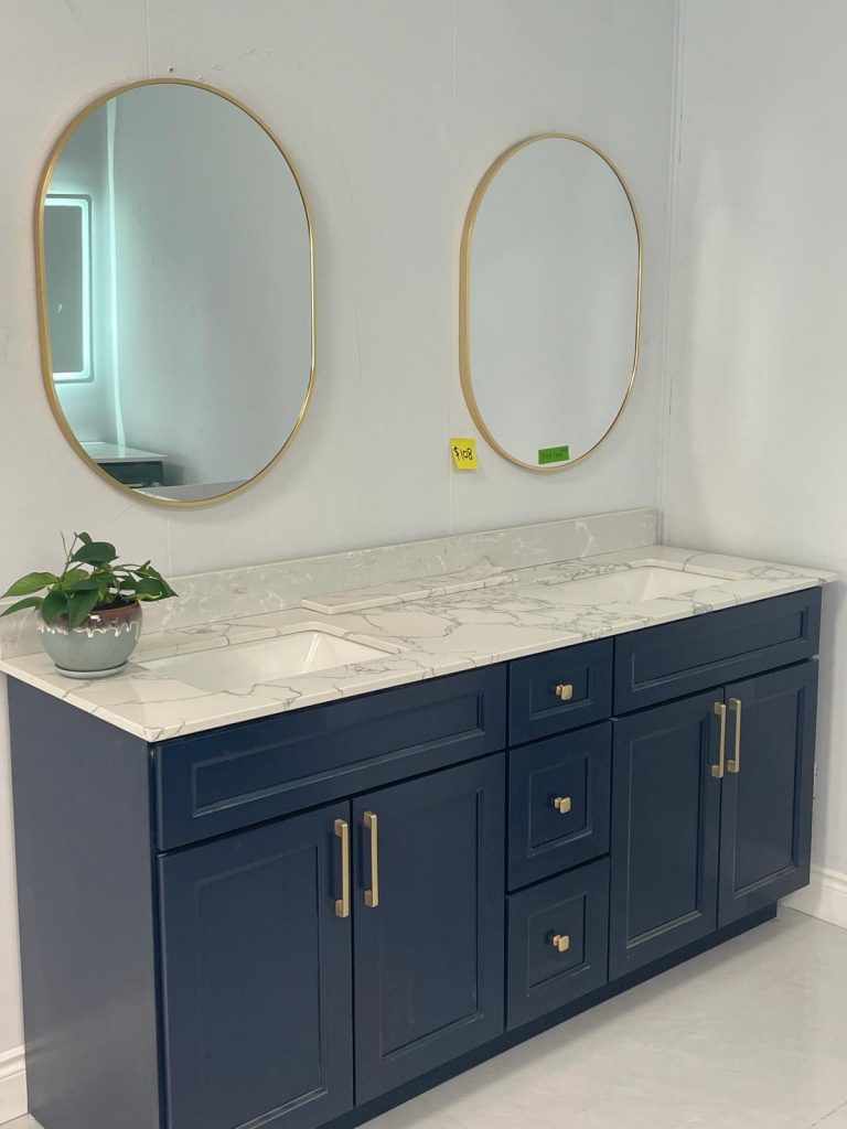 Prussian blue bathroom vanity with gold handles and round mirror by Supply Toronto